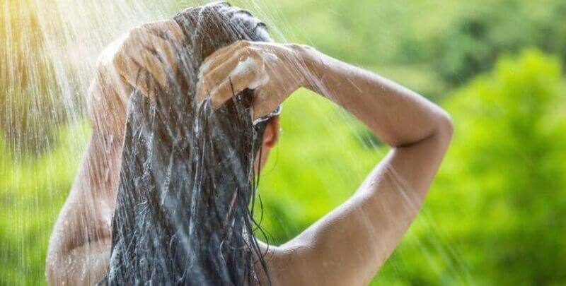 A woman uses an outdoor shower