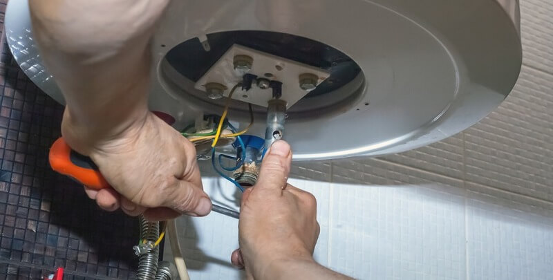 repairman hand are fixing broken electric boiler